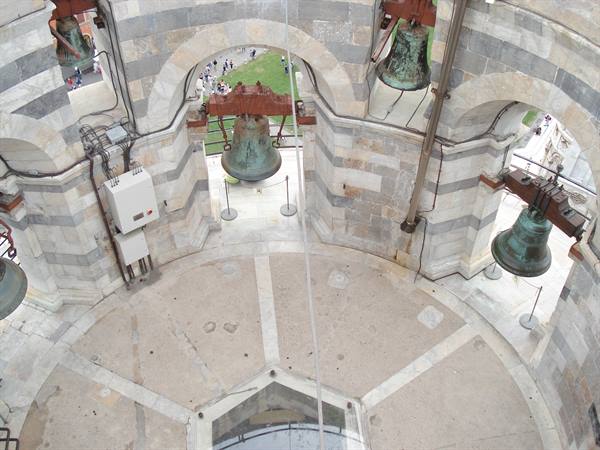 Bronze bells in the bell chamber of the Leaning Tower of Pisa, marble arches