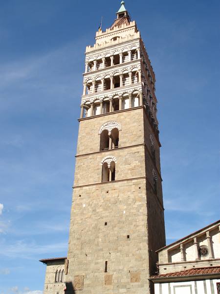 Romanesque stone bell tower of Pistoia, tiered loggias against blue sky