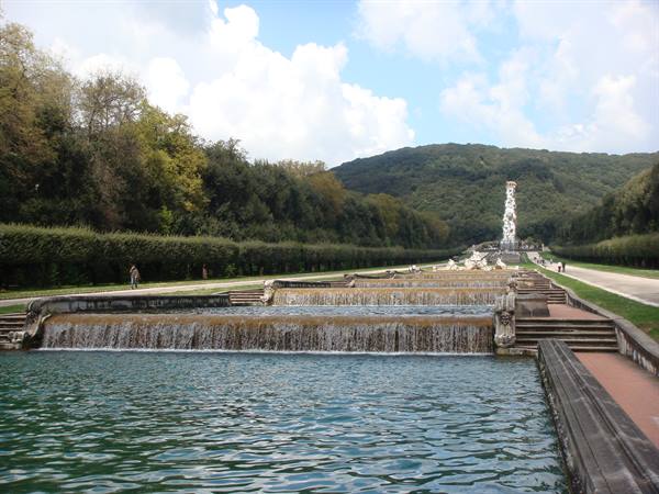 Cascading fountains of the royal gardens of Caserta, green hills behind