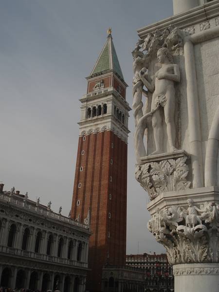 St Mark's Campanile in Venice beside a marble column with statues