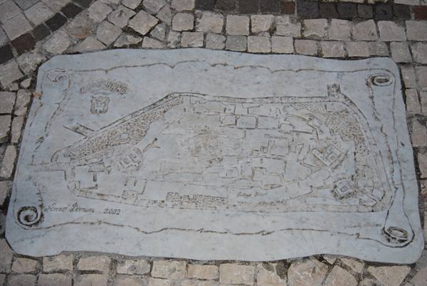 City map carved into a marble slab embedded in cobblestone pavement
