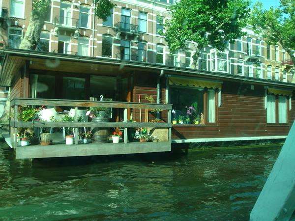 Wooden houseboat with flower pots on deck, Amsterdam
