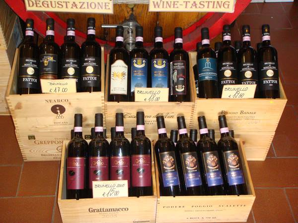 Brunello and Vino Nobile bottles displayed in wooden crates, wine tasting in Montepulciano