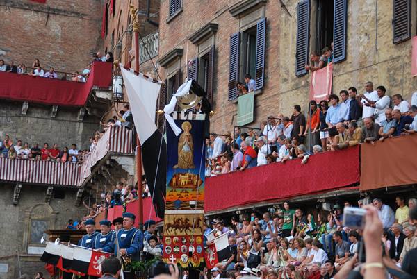 Palio di Siena: flag bearers with banners amid crowds on balconies