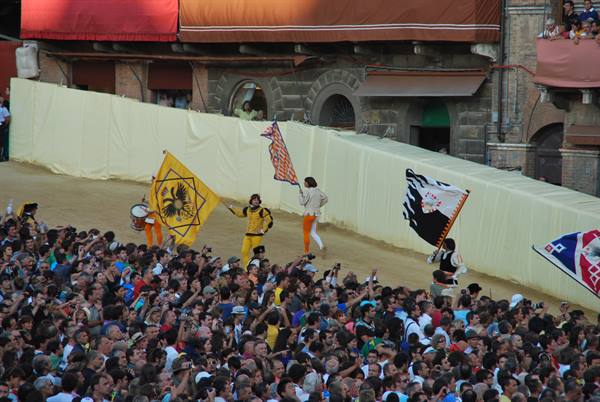Flag bearers parading in Siena's Piazza del Campo during the Palio