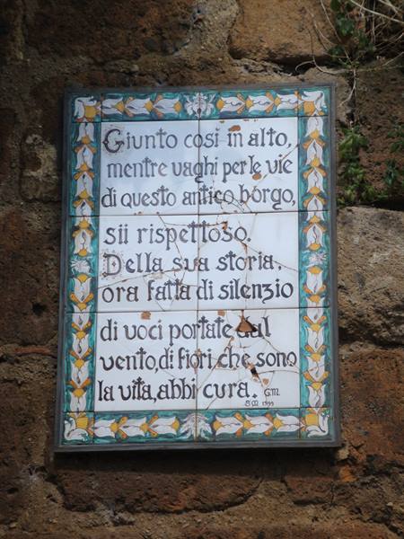 Majolica tile plaque with a poem on tufa wall, Civita di Bagnoregio