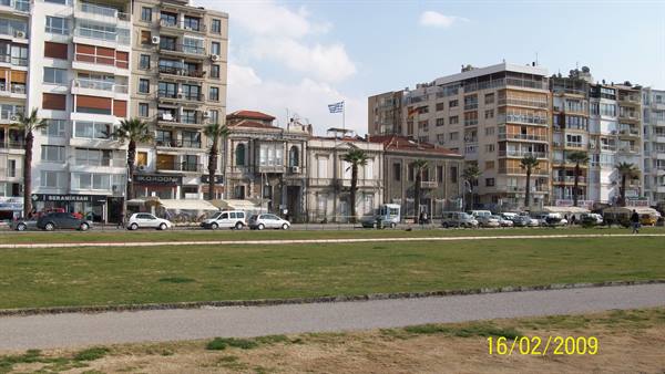 Buildings and historic structures along Thessaloniki waterfront, with palms and lawn