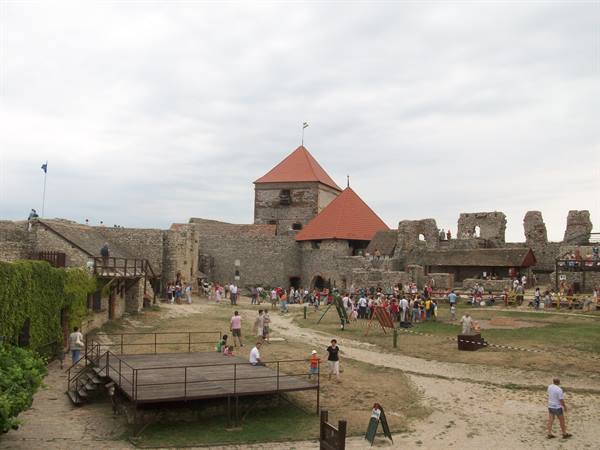 Visitors in the stone castle courtyard with red-roofed towers