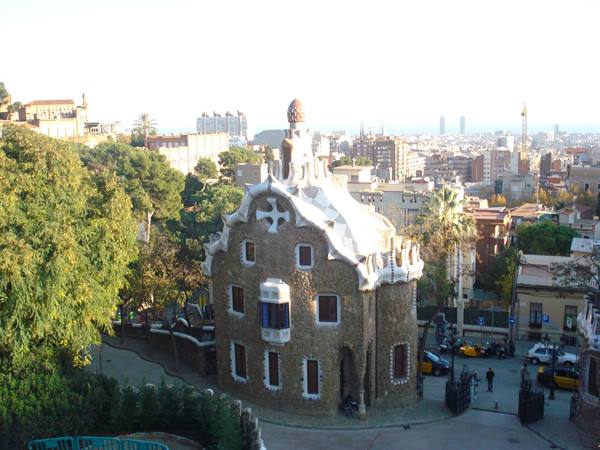 Gaudí's stone gatehouse with curved tiled roof at Park Güell, Barcelona
