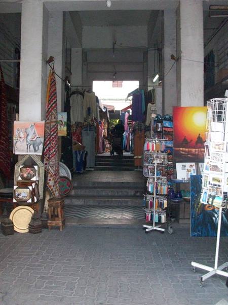 Covered souk with steps, carpets, paintings and postcards on sale