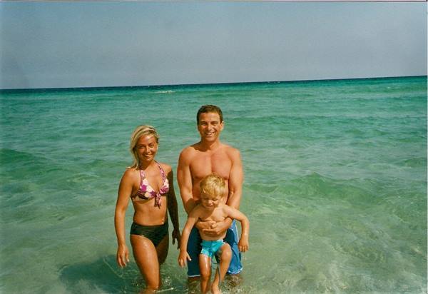 Couple with child in turquoise sea, clear water, sunny day