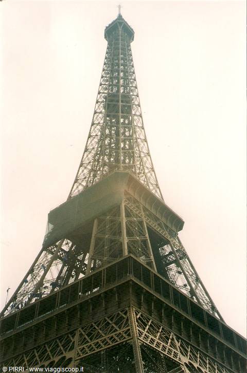 The wrought-iron Eiffel Tower rising into Paris's hazy sky