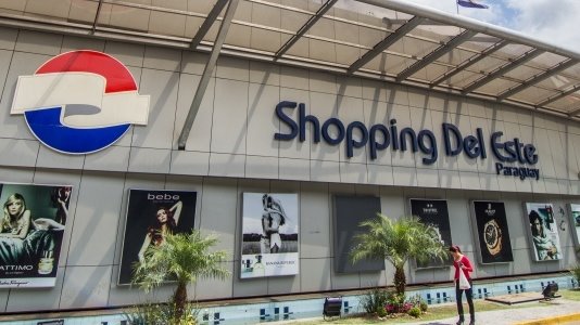 Donna fotografata davanti alla facciata del centro commerciale Shopping Del Este con insegne Pepsi