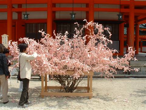 they look like flowers but they're votive slips tied to the branches