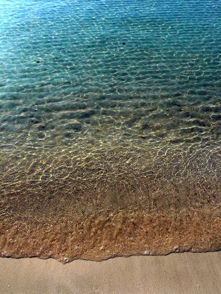 Crystal clear water gently lapping the golden sandy shore