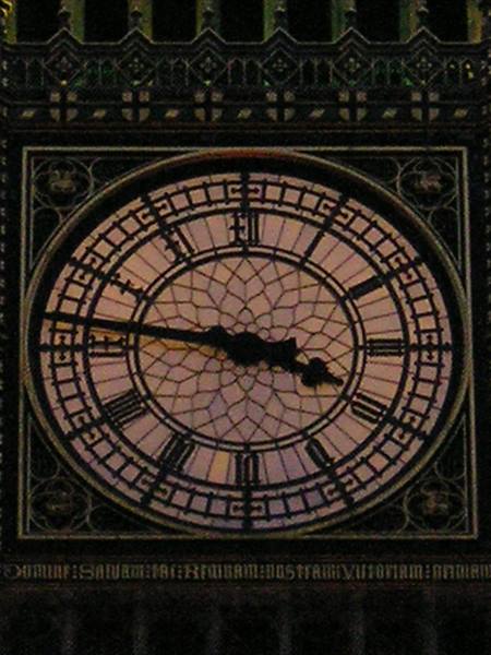 Big Ben clock face at night, glass dial with dark hands