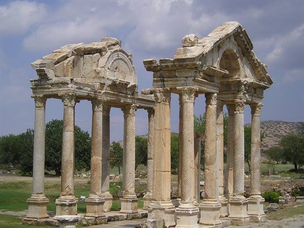 The Tetrapylon of Aphrodisias, carved marble twisted columns under a cloudy sky
