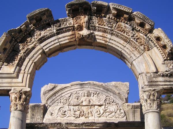 Carved arch of the Temple of Hadrian in Ephesus, sculpted marble against blue sky