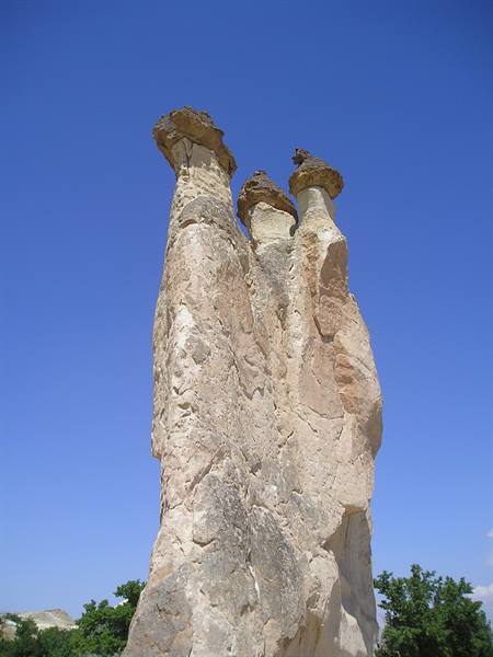 Tuff fairy chimneys with mushroom caps under blue sky, Cappadocia