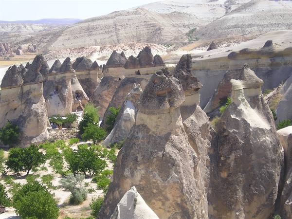 Fairy chimneys carved in volcanic rock at Göreme, Cappadocia, among green trees