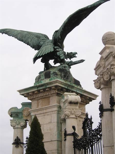 Bronze raven statue with spread wings on stone column, Buda Castle