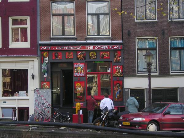 The Other Place café in Amsterdam, people and motorcycles by the red facade