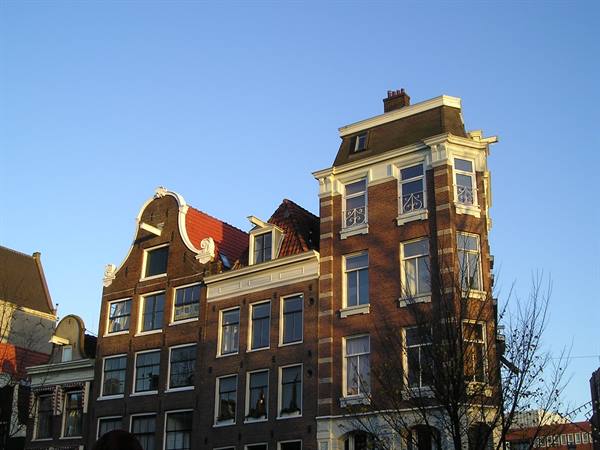 Brick facades with curved gables in Amsterdam, golden morning light