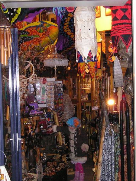 Child in white coat among colorful lanterns and umbrellas in a souvenir shop