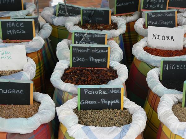Spice sacks with chalkboard signs: green pepper, niora, mace, open-air market