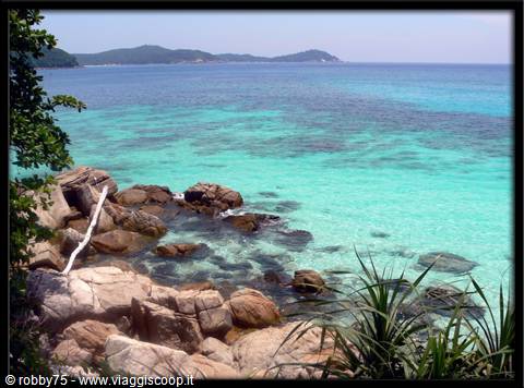Granite rocks over turquoise water, distant islands and tropical vegetation at Pulau Redang