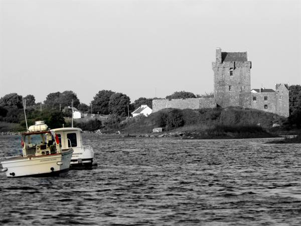 Fishing boats in the foreground before the stone Dunguaire Castle