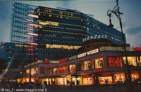 Gerry Weber and Franzie lit signs beneath the glass building at dusk