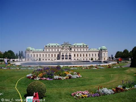 Belvedere Palace in Vienna with fountain and flowerbeds under sunny sky