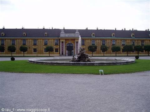 Fountain in front of the yellow baroque facade of Schönbrunn Palace