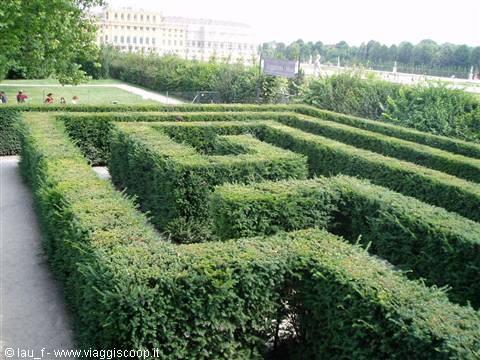 Hedge maze in the gardens of Schönbrunn, visitors resting on the lawn