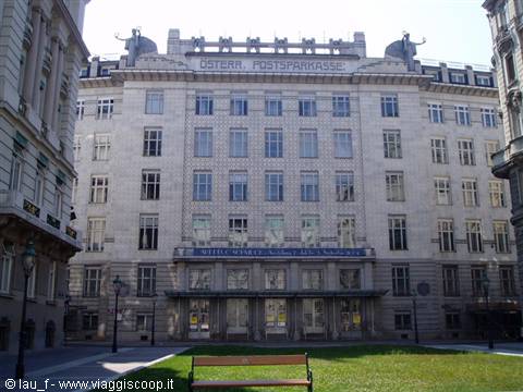Marble facade of the Vienna Postsparkasse with a bench on the lawn