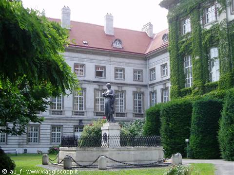 Statue on a fountain in the courtyard of an ivy-covered palace