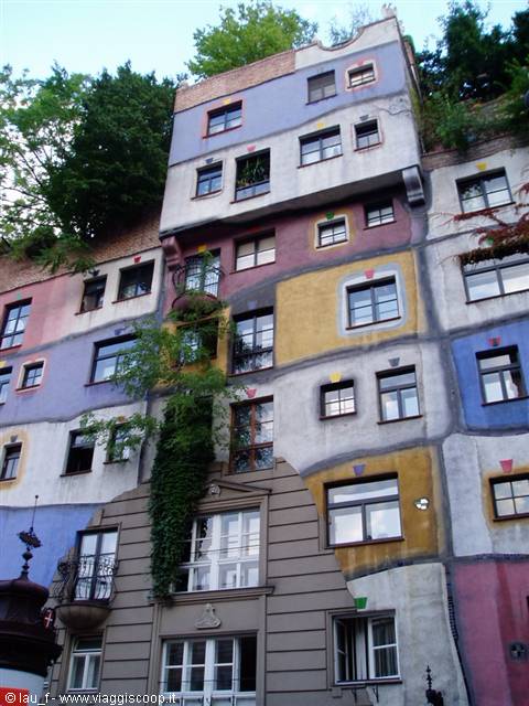 Colorful facade of the Hundertwasserhaus in Vienna with uneven windows and ivy