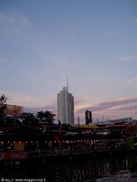 Riverside food stalls in Vienna, Florido Tower against evening sky