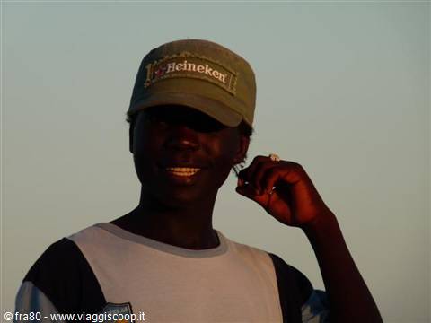 Smiling young man wearing a Heineken cap and ring in golden light