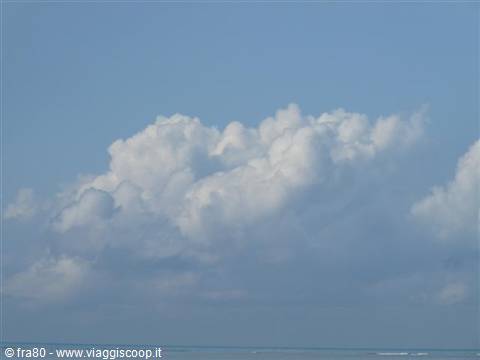 White clouds above the blue sea on a clear day