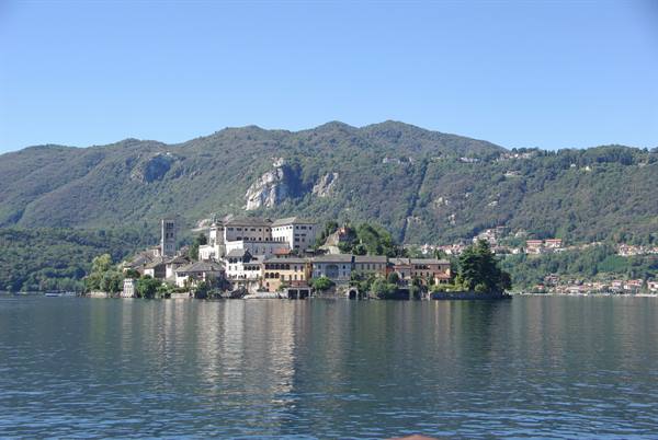 Isola San Giulio on Lake Orta, houses and bell tower reflected in calm water