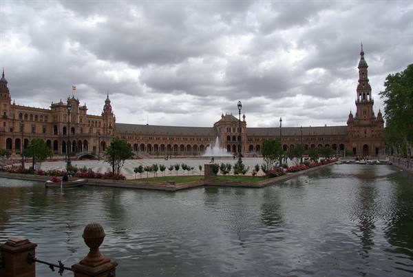 Plaza de España in Seville, canal, fountain and tower under cloudy sky