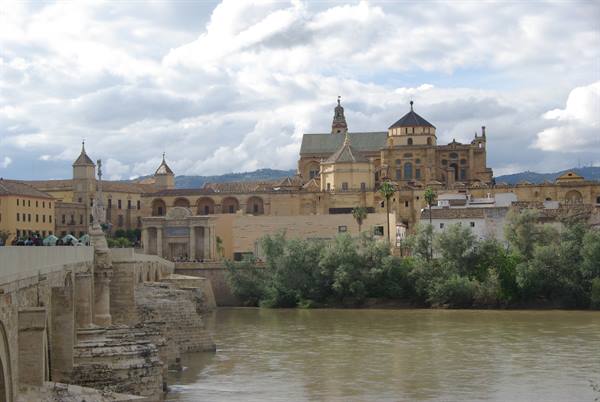 Roman bridge over the Guadalquivir and Cordoba's Mezquita under clouds