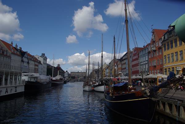 Sailboats moored along Nyhavn canal between colorful old townhouses