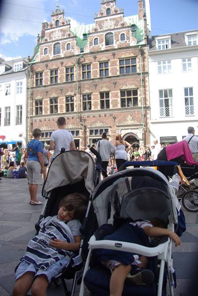 Sleeping kids in strollers before the historic Royal Copenhagen brick facade