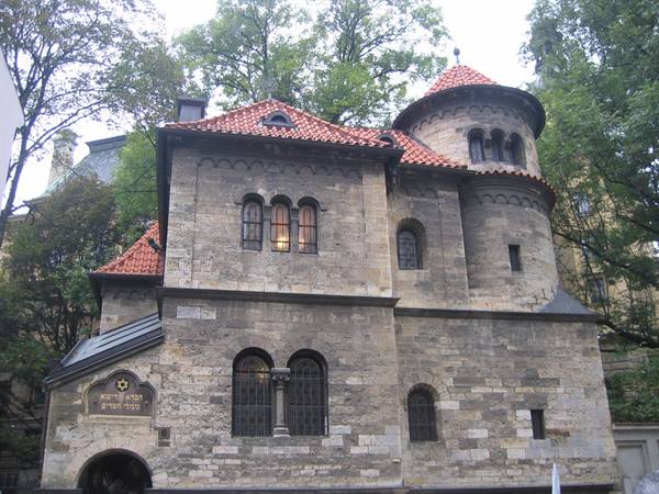 Klausen Synagogue in Prague, grey stone and red roofs among trees