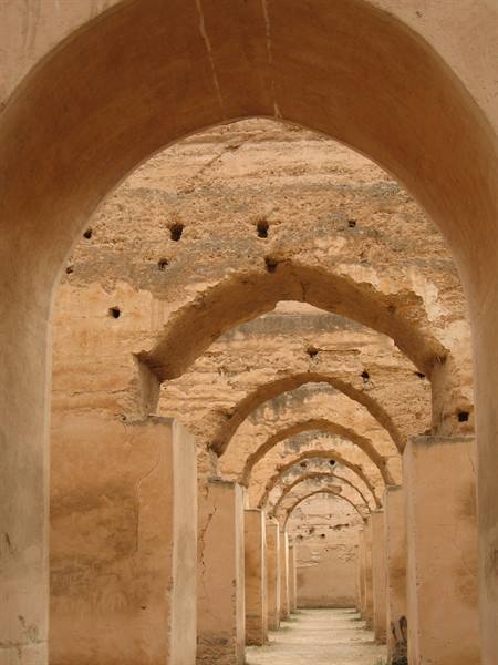 Rows of earthen brick arches inside the royal stables of Meknès