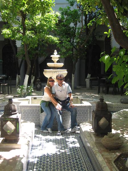 Couple sitting before a fountain in a courtyard with tiles and lanterns