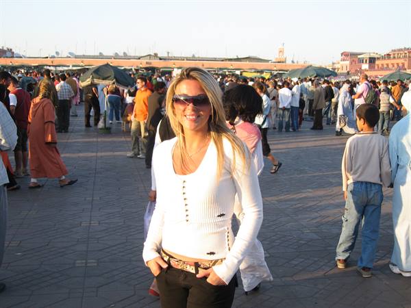 Smiling tourist in sunglasses in the crowded Jemaa el-Fna square, Marrakech